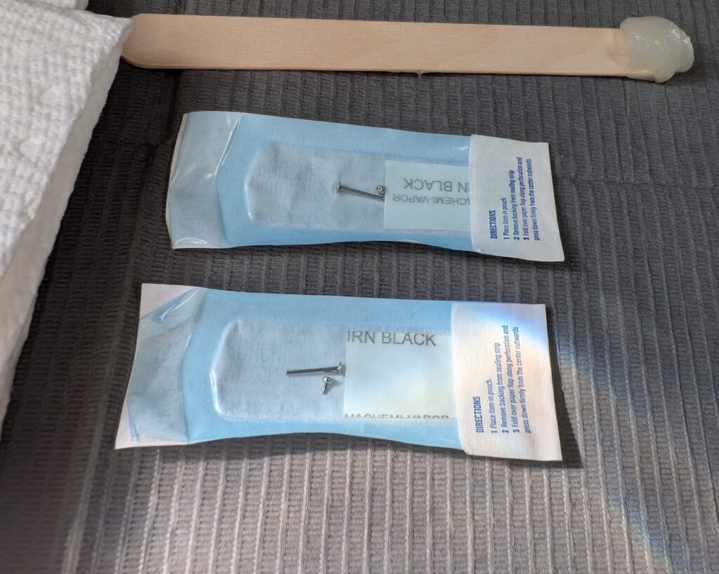 Two pieces of sterile, unopened piercing jewelry ready for piercing prep