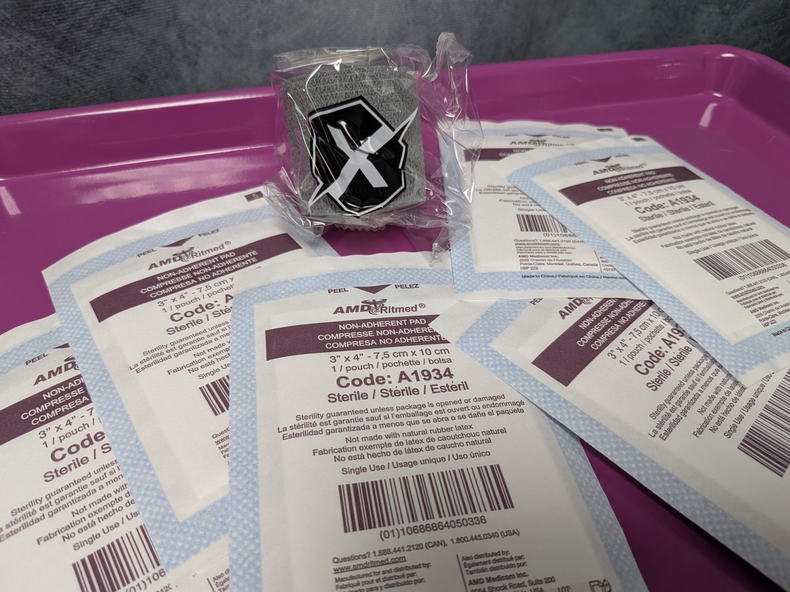 Sterile gauze pads and medical wrap (Sensi-wrap) prepared on a rolling artist's tray for a safe tattoo session.